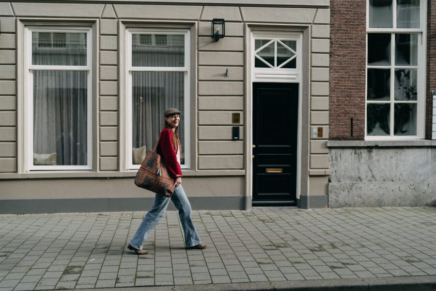 Vrouw loopt door de stad met de etatoua tas over haar schouder