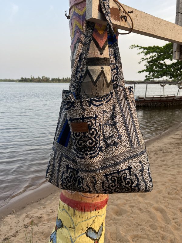 De Etatoua Tas in het blauw hangt aan een paal en is de ideale strandtas